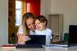 © Jelena Stanojkovic - Happy laughing single mother and little preschool cute son using laptop online application,making video call,having fun,babysitter teaching small boy use computer,watching cartoons together.Copy space