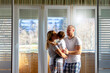© Jelena Stanojkovic - Portrait of beautiful young family standing on balcony and having fun together.Shot of happy family playing at home.Image of husband and wife in pajamas standing on balcony,and holds their son in arms