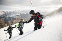 Skier Helping Snowboarder Climb Steep Snowy Mountain Ski Slope