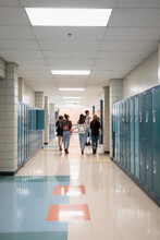 High School Students Walking Past Lockers In Corridor