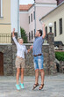 © danmorgan12 - Vacations Travel Ideas. Happy Caucasian Couple Having Fun and Jumping Together With Outstretched Hands During Traveling in The City.