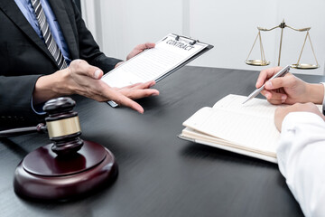 A male lawyer or a judge counseling clients about judicial justice and prosecution with scales, judges gavel, legal documents legal services concept