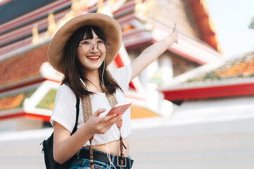 Wall Mural - Young asian travel energetic girl listen streaming music with smart phone.