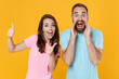 © ViDi Studio - Excited young couple two friends guy girl in blue pink t-shirts isolated on yellow background. People lifestyle concept. Mock up copy space. Screaming with hands gesture near mouth, showing thumbs up.