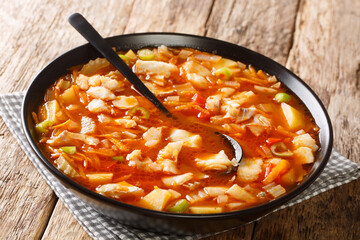 Wall Mural - Bermuda Fish Chowder With Onion, Green Bell Pepper, Leek, Carrots, Celery, Tomato, Garlic Cloves close-up in a bowl. Horizontal