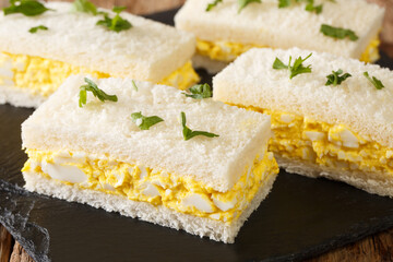 Wall Mural - japanese egg sandwiches close-up on a slate board on the table. horizontal