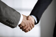 © rogerphoto - Business people in office suits standing and shaking hands, close-up. Business communication concept. Handshake and marketing