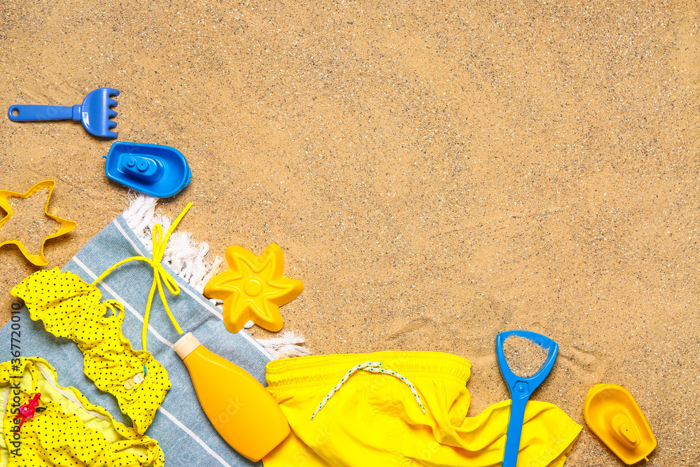Set of beach accessories for children on sand, top view