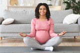 Fototapeta  - Happy black expecting lady meditating at home