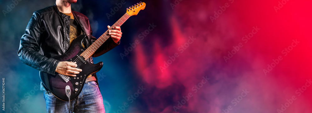 Guitar player performs on stage. Rock guitarist plays solo on an electric guitar. Artist and musician performs like rockstar. - obrazy, fototapety, plakaty 