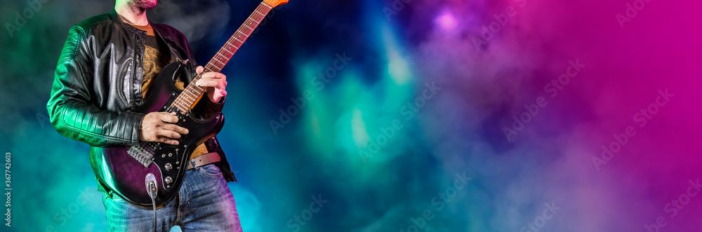 Guitar player performs on stage. Rock guitarist plays solo on an electric guitar. Artist and musician performs like rockstar. Black and white version. Green and pruple version. Panoramic image. - obrazy, fototapety, plakaty 
