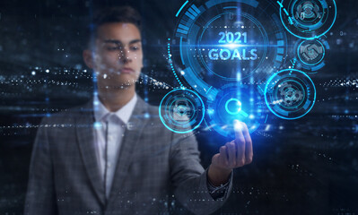 Business, Technology, Internet and network concept. Young businessman working on a virtual screen of the future and sees the inscription: 2021 goals