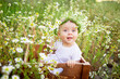 © Any Grant - portrait of a baby girl 7 months old sitting on a chamomile field in a wreath in a white dress, a healthy walk in the fresh air