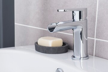 Canvas Print - New and modern steel faucet with the ceramic sink in the bathroom