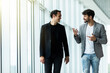 © F8  \ Suport Ukraine - Two young businessmen talking while walking through office corridor