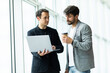 © F8  \ Suport Ukraine - Two cheerful businessmen discussing something on the laptop in an office
