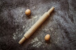 ingredients for baking bread, eggs, rolling pin lie on a gray table