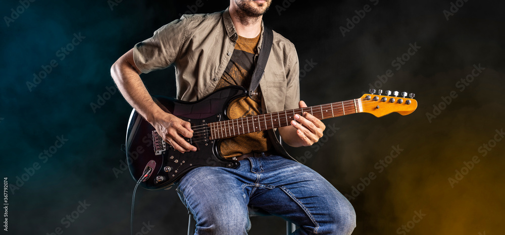 Jazz guitar player performing on electric guitar. Male guitarist musician plays blues and jazz. - obrazy, fototapety, plakaty 