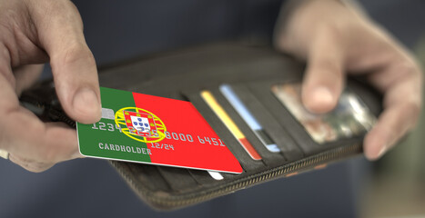 Man pulls credit card with flag of Portugal out of his wallet, fictional card number