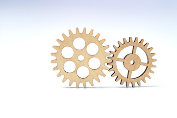 two elements business concept, wooden gears on a white background, vignetting