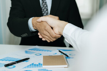 Wall Mural - Partnership. two business man investor handshake deal with partner after finishing up business meeting on desk in meeting room office, financial, teamwork, job interview, contract agreement concept