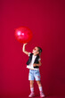 © skif - stylish and cool little girl in sunglasses, leather vest playing big red balloon