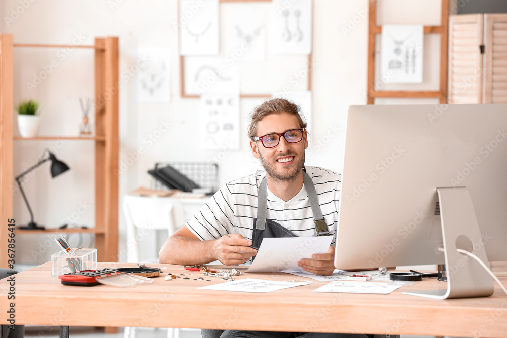 Male jewelry designer working in office