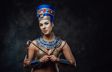 Lady in traditional egyptian blue and gold costume with distinctive symbols of power in her hands