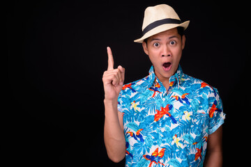 Young Asian tourist man ready for vacation against black background