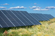 © Pink Badger - Energy park with solar panels in green meadow on blue sky