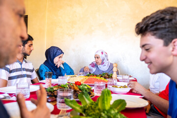 Wall Mural - Happy arabic muslim family eating together in a family meeting