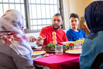 Wall Mural - Arabic muslim family eating together in a meeting for iftar in ramadan