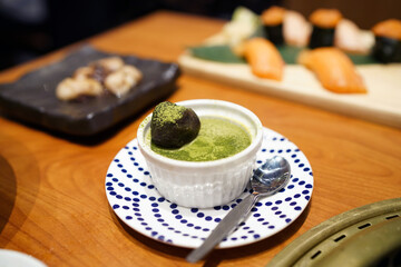 Matcha green tea pudding with red bean and topped with match powder, Japanese dessert style.