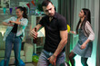 © DC Studio - Attractive young man with a beer bottle in his hand dancing at a party with friends. Girl with balloon.