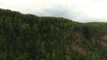 Pine Trees Growing On Rocky Cliffsides Of Quebec In Canada On Overcast Day