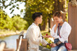 © AnnaStills - Woman holding engaged ring and making proposal to her girlfriend while they have date in the park