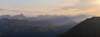 Panorama of alpine mountains during a hazy sunset