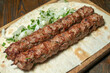 lula kebab with herbs on a wooden surface