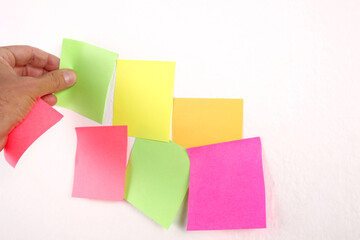 male hand put a balnk paper sticky note on the wall with copy space for your text