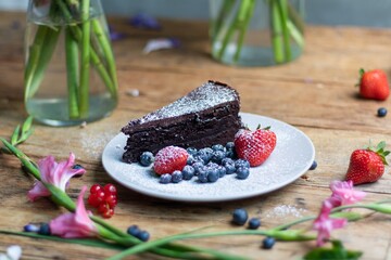 Poster - Closeup shot of a piece of brownie cake with blueberries and strawberries