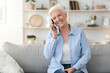 © Prostock-studio - Communication Concept. Smiling elderly woman talking on mobile phone at home