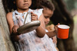 Selective focus of poor African american children begging alms on urban street