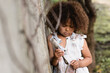 Selective focus of poor and upset african american child holding dirty metal spoon and plate in slum