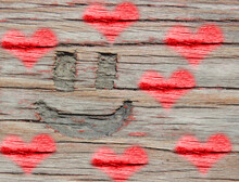 A Smiling Face Is Carved On An Old Wooden Surface, And Toning Red Hearts    