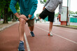 © JustLife - Young men exercising on a race track. Two young friends training in park