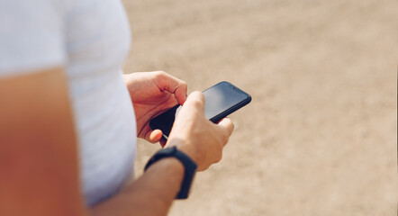 Hands of man touching phone display. Lifestyle, travel, technology concept. Copy space