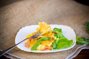 Sticker - fried home omelet with vegetables and arugula in a plate