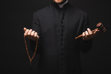 Sticker - cropped view of priest holding wooden gavel and rosary beads in hands isolated on black