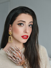 Wall Mural - Close up headshot portrait of young natural looking casual beautiful brunette woman with trendy makeup and vibrant red lips liten by natural light domestic room background