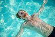 © zinkevych - Young bearded man lying in water on his back